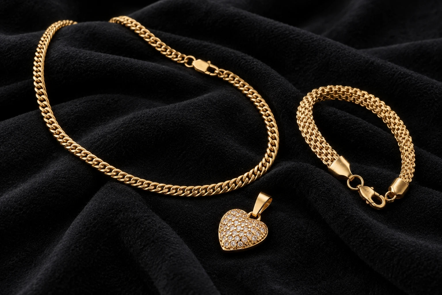 Combinación de cadena, pulsera y dije en oro laminado sobre una superficie negra